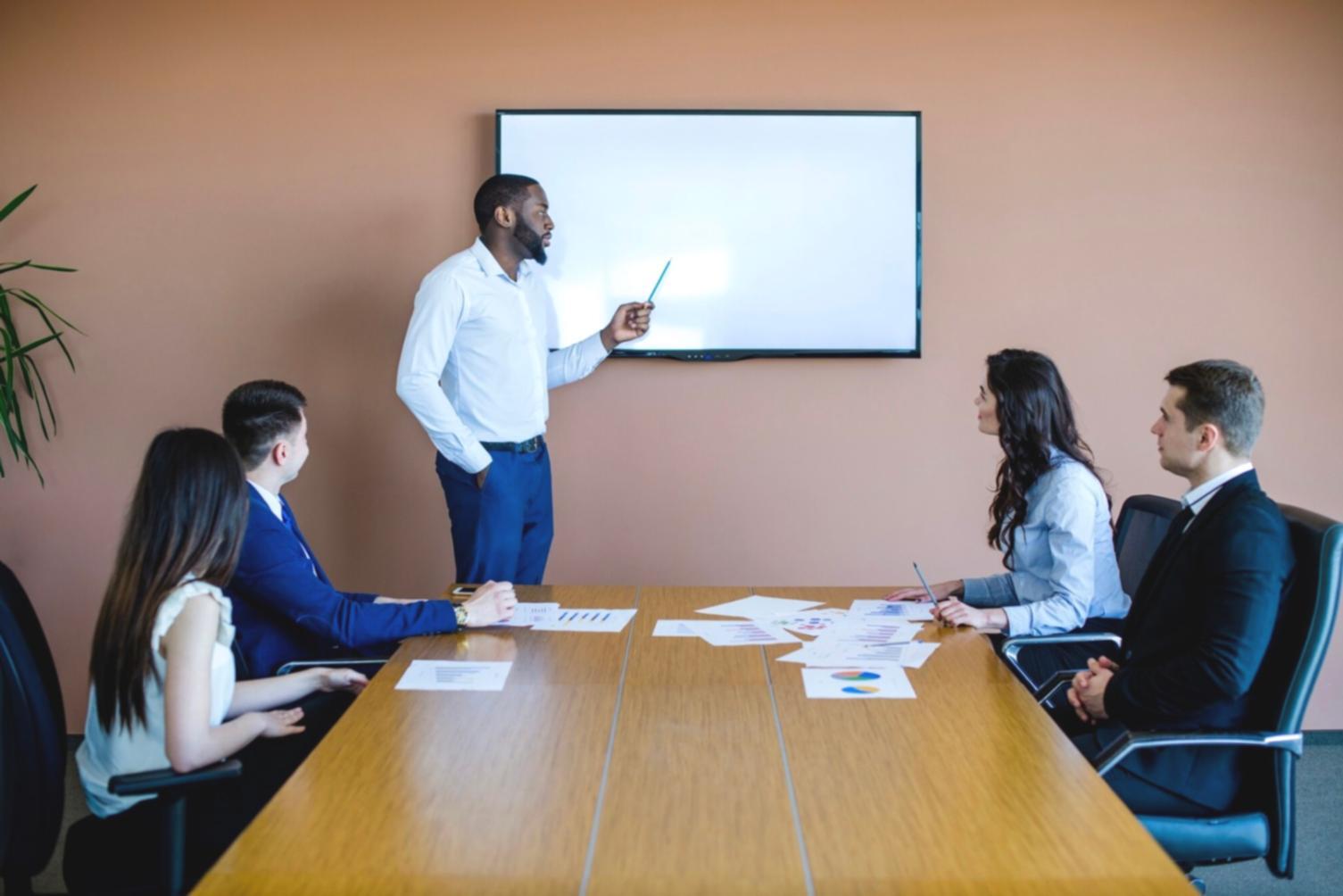 Professional mentor reviewing financial documents with student in modern office setting